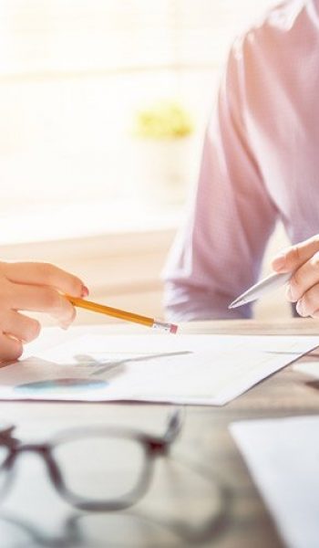 Multifunction Copier Benefits People discussing printed reports on the desk